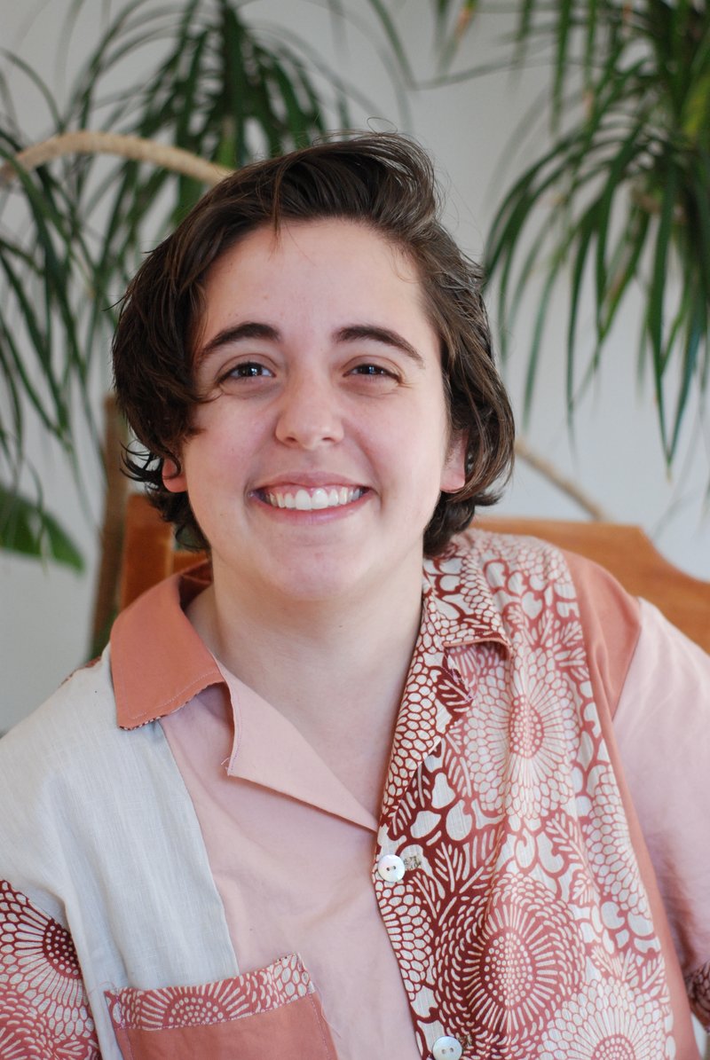 Rachel Ameen smiling in front of a houseplant